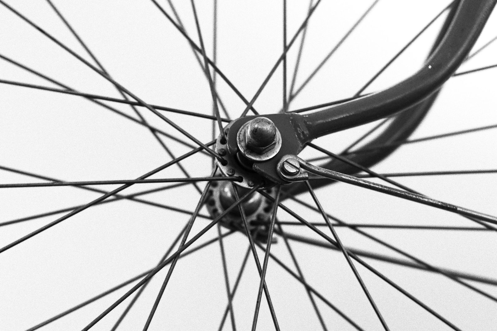 Black-and-white close-up of a bicycle wheel hub and spokes.