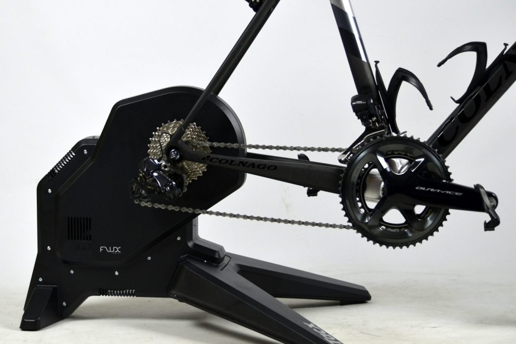 A road bike mounted on a black Tacx direct-drive smart trainer with the rear wheel removed.