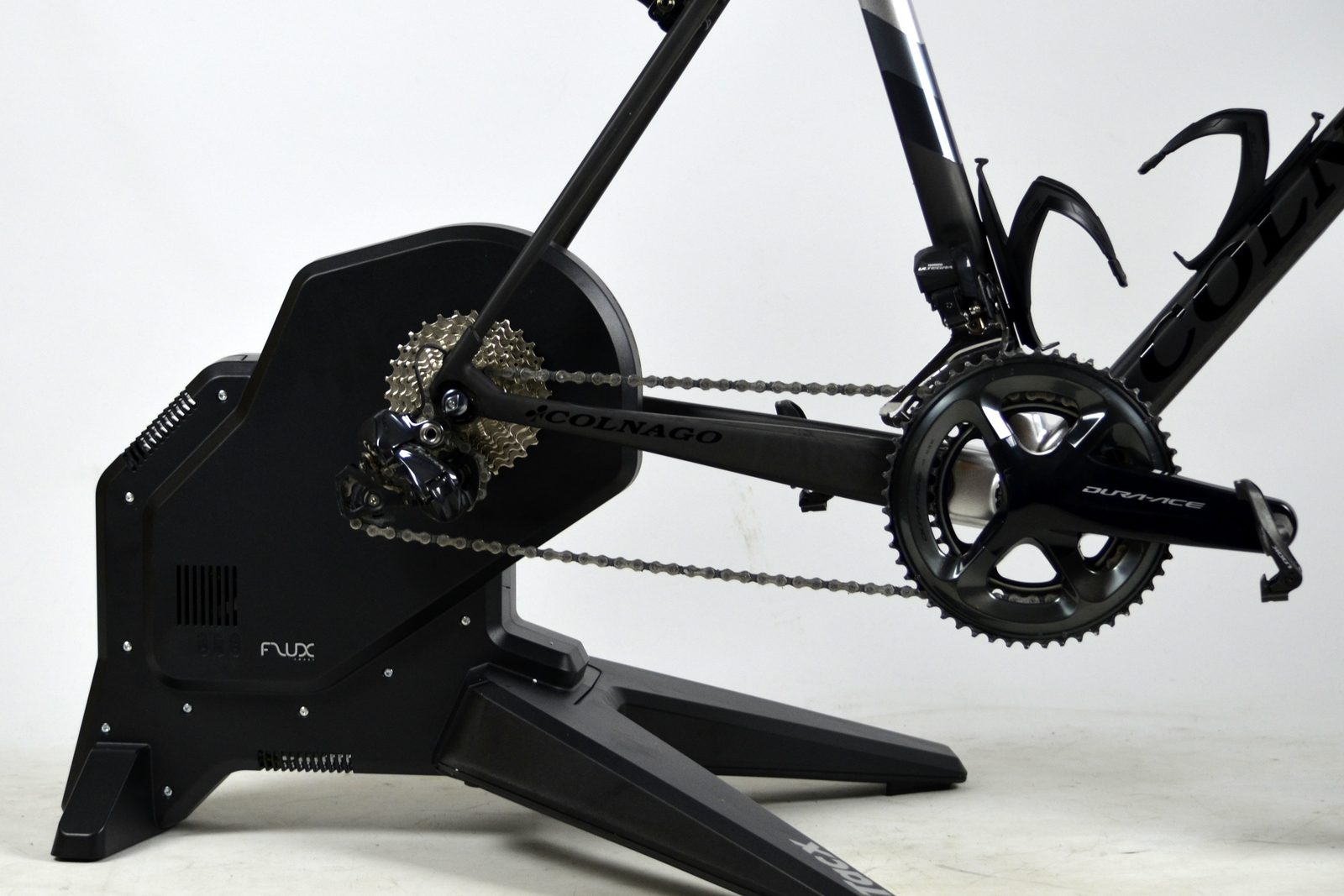 A road bike mounted on a black Tacx direct-drive smart trainer with the rear wheel removed.